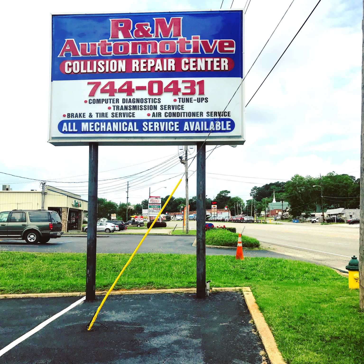The R&M Automotive Collision Repair Center road sign on Allison Bonnett Memorial Drive